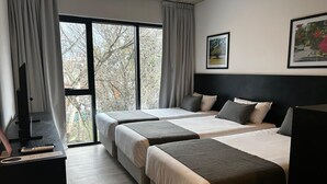 A hotel room with two beds, a desk with a computer, and a large window with curtains. - Mérit Parque Leloir by Amérian (Villa Udaondo)