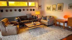 A cozy living room with a sofa, armchairs, a coffee table, and a rug.