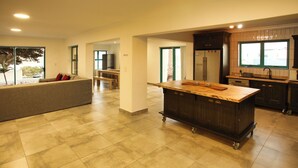 A spacious kitchen with a central island, dark cabinetry, and a large window providing natural light. - The Spry House, Langebaan, 8 Sleeper (Langebaan)