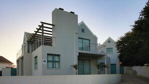 A modern two-story building with a balcony, a staircase, and a warning sign. - The Spry House, Langebaan, 8 Sleeper (Langebaan)