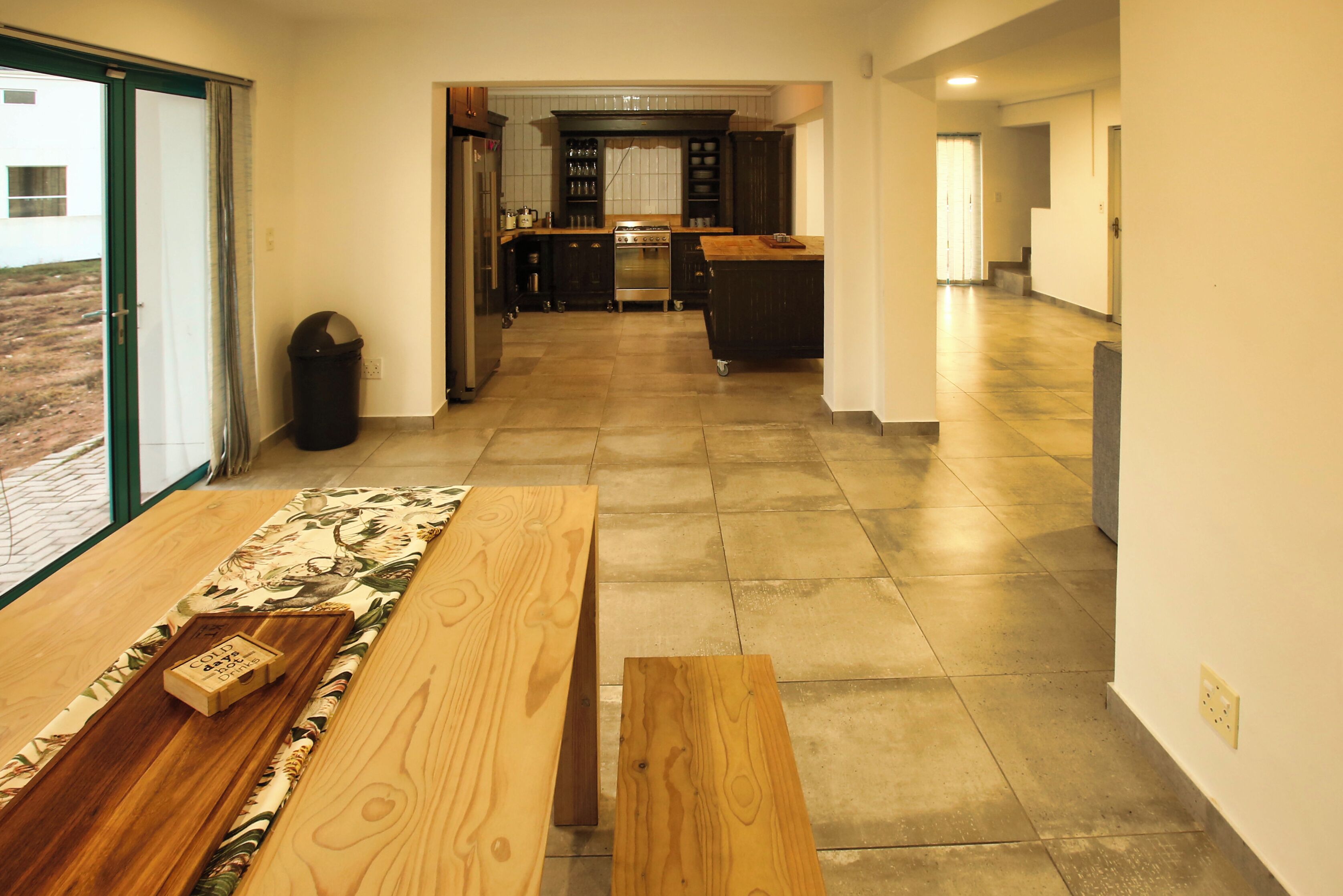 A modern kitchen with dark cabinetry, a stainless steel oven, and a wooden countertop.