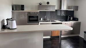 A modern kitchen with stainless steel appliances, a built-in oven, microwave, and dishwasher. - Au Coeur du Vignoble, Magnifique vue Avec Terrasse (Westhalten)