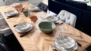 A dining area with a wooden table set for four, surrounded by dark upholstered chairs. A large window provides a view of the outdoors. - Au Coeur du Vignoble, Magnifique vue Avec Terrasse (Westhalten)