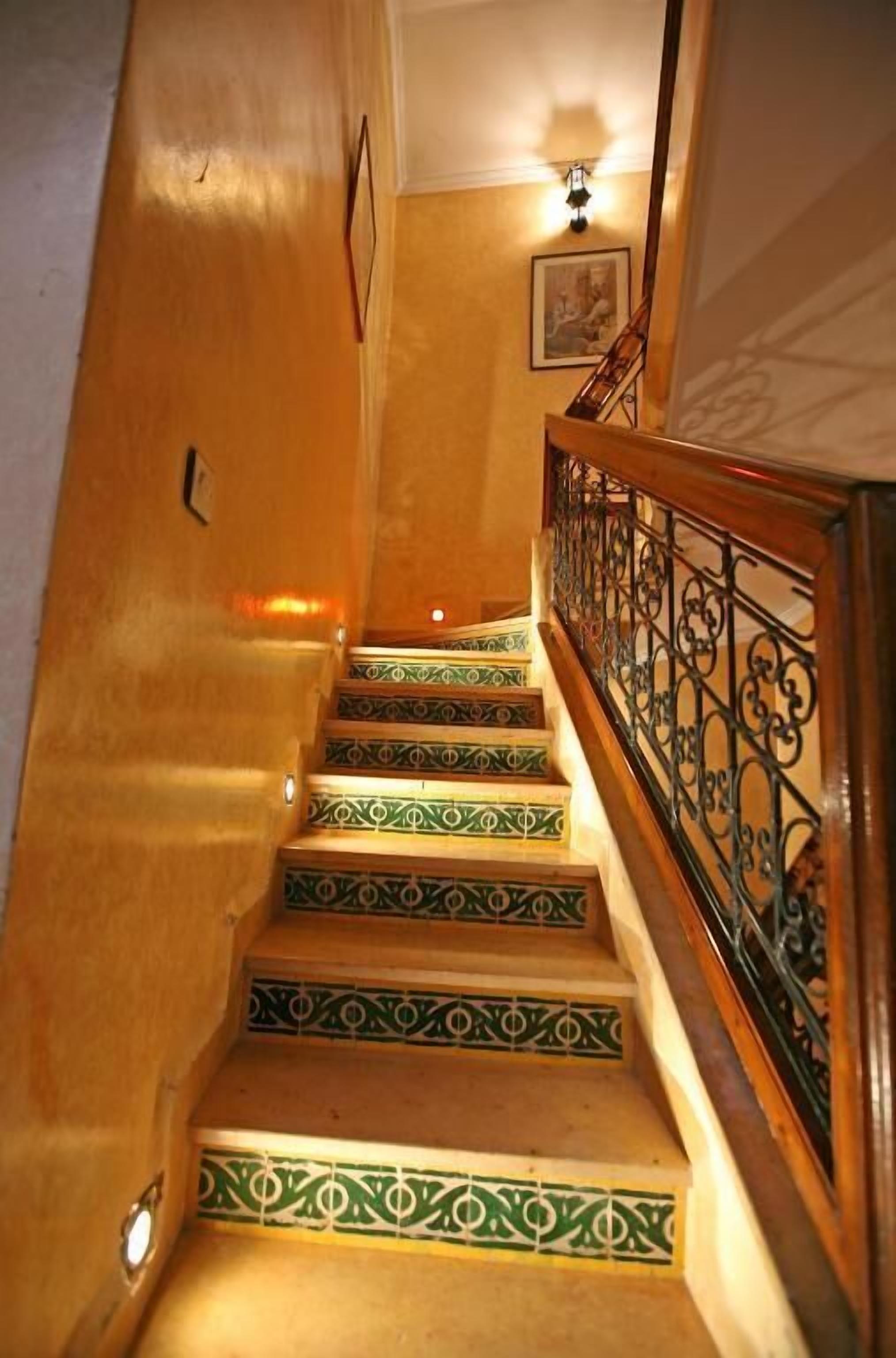 A staircase with green patterned steps and a wooden railing.