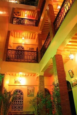 A multi-level interior with balconies, staircases, and decorative lighting. - Riad Taghazoute (Marrakech)