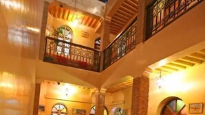A multi-level atrium with balconies, wooden railings, and a central open space. - Riad Taghazoute (Marrakech)