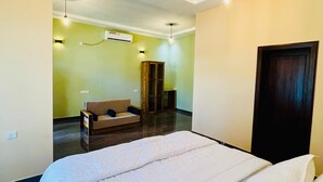 Una habitación de hotel con una cama grande, un sofá, un escritorio y un armario.