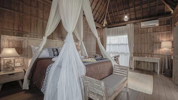 Una habitación de madera con una cama con dosel, una mesita de noche, un banco y una mesa.