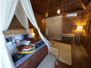 A wooden room with a bed, a table, and a chair.