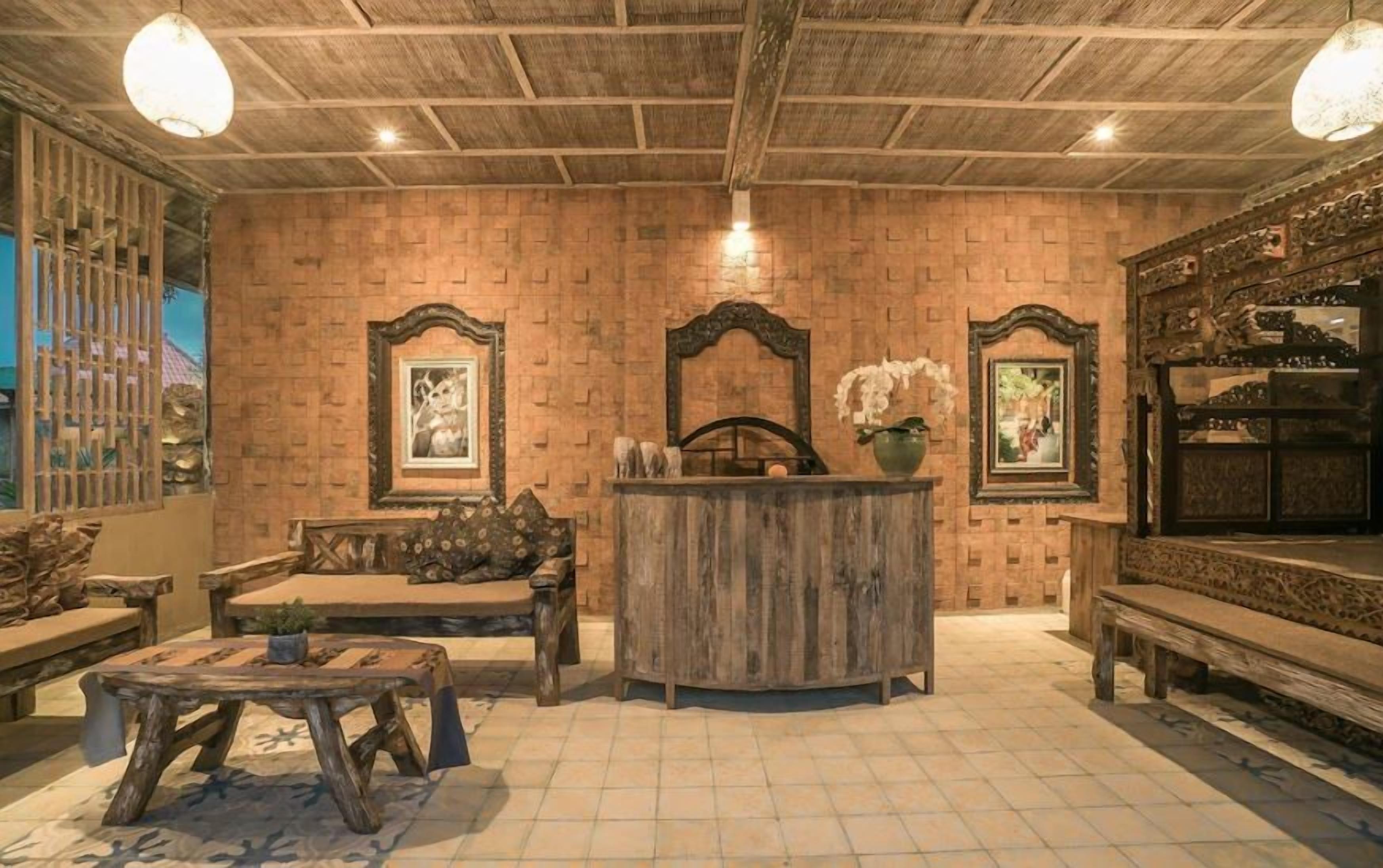 A rustic interior with a wooden ceiling, a central wooden bench, a small table, and a decorative mirror.