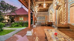 A traditional Balinese house with a wooden roof, a tiled floor, and a garden area. - Kirani Joglo (Celuk)
