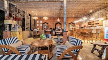 Un restaurante acogedor con muebles de madera, una zona de bar y una estantería.
