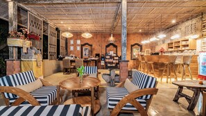 Un restaurant chaleureux avec des meubles en bois, un coin bar et une bibliothèque.