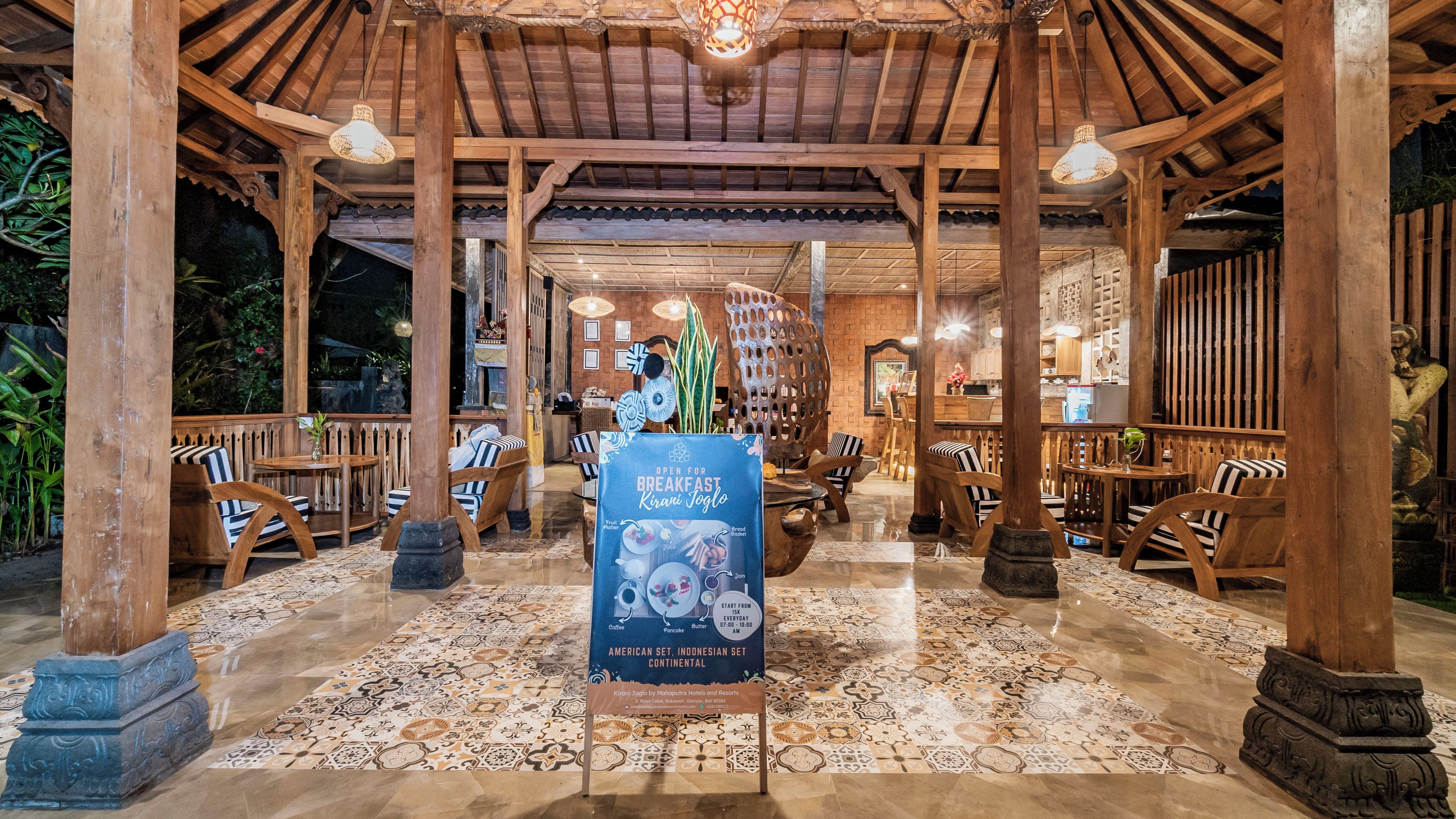 Um restaurante com interior em madeira, chão de azulejos e um letreiro anunciando café da manhã.