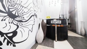 Zona de recepción con diseño moderno, que incluye un mostrador negro con la leyenda