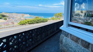 A balcony with a stone balustrade overlooking a coastal town, a clear sky, and the sea. - Stunning iconic harbour & sea views of St Ives, parking and 2 mins walk to town (St Ives)