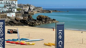 A beach with kayaks and a sign that reads "Ice Cream." - Stunning iconic harbour & sea views of St Ives, parking and 2 mins walk to town (St Ives)