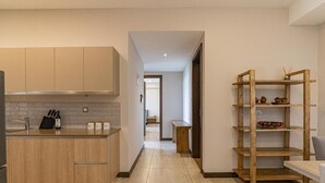 Une cuisine moderne avec des meubles de rangement en bois, un plan de travail et une étagère en bois.