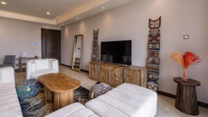 Un salon moderne avec un canapé, une table basse et un téléviseur. On y trouve également un meuble en bois et un élément décoratif mural.