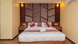 A hotel room with a large bed, wooden headboard, and a modern ceiling design. - Hotel Royal Airport (Kathmandu)