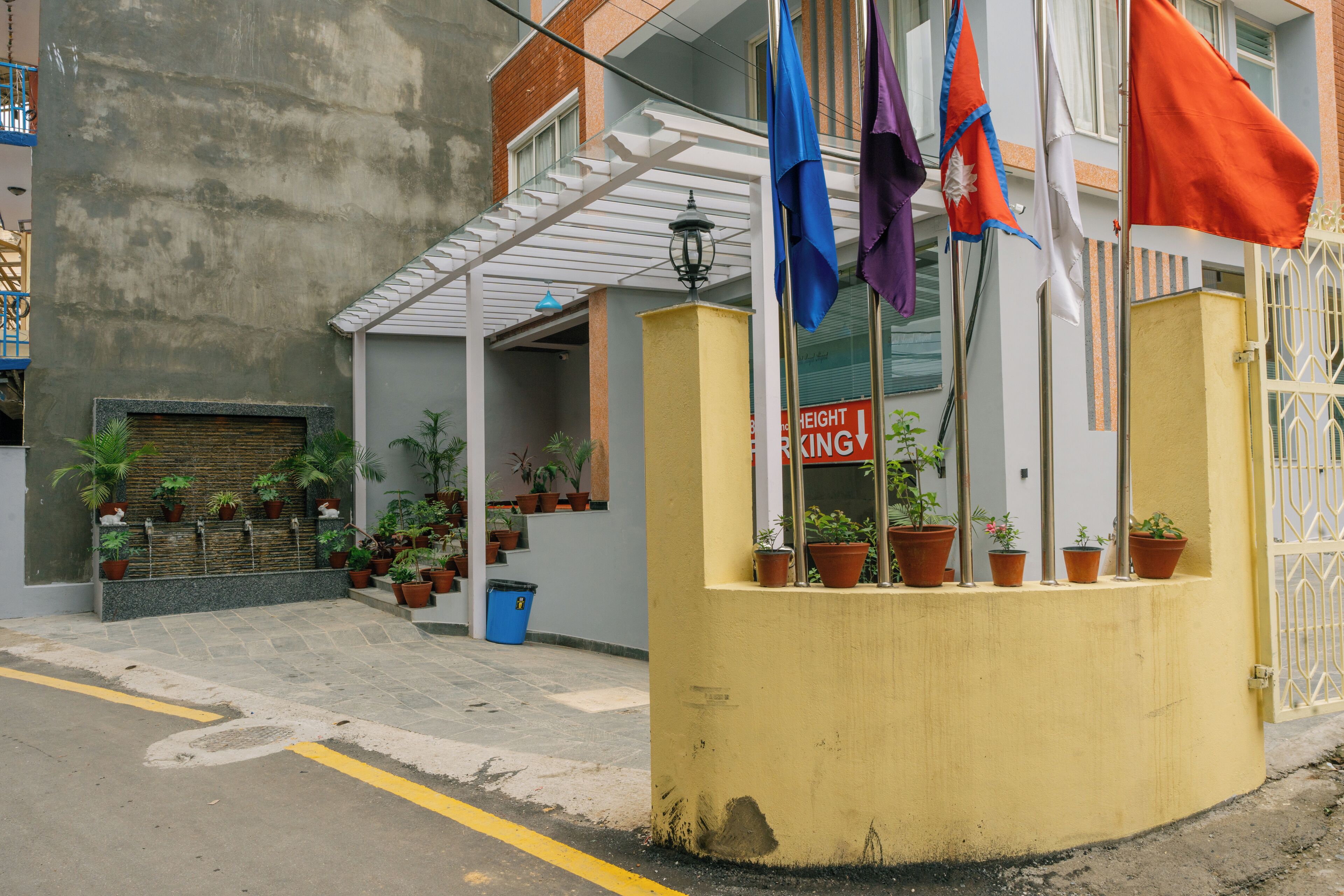 A building with a yellow facade, potted plants, and a sign that reads "HEIGHT KING."