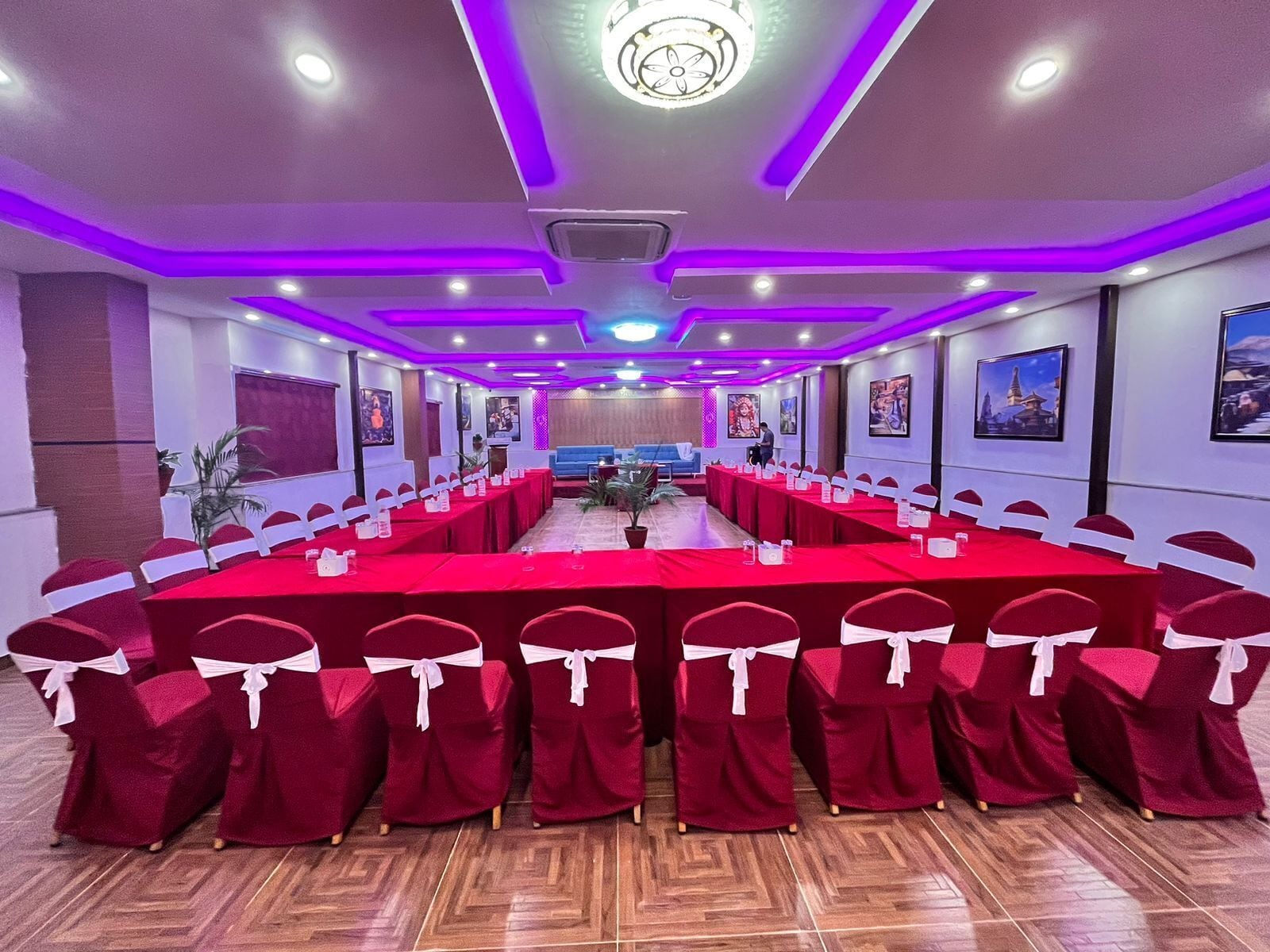Une salle de conférence avec une longue table, des chaises rouges et un éclairage violet.