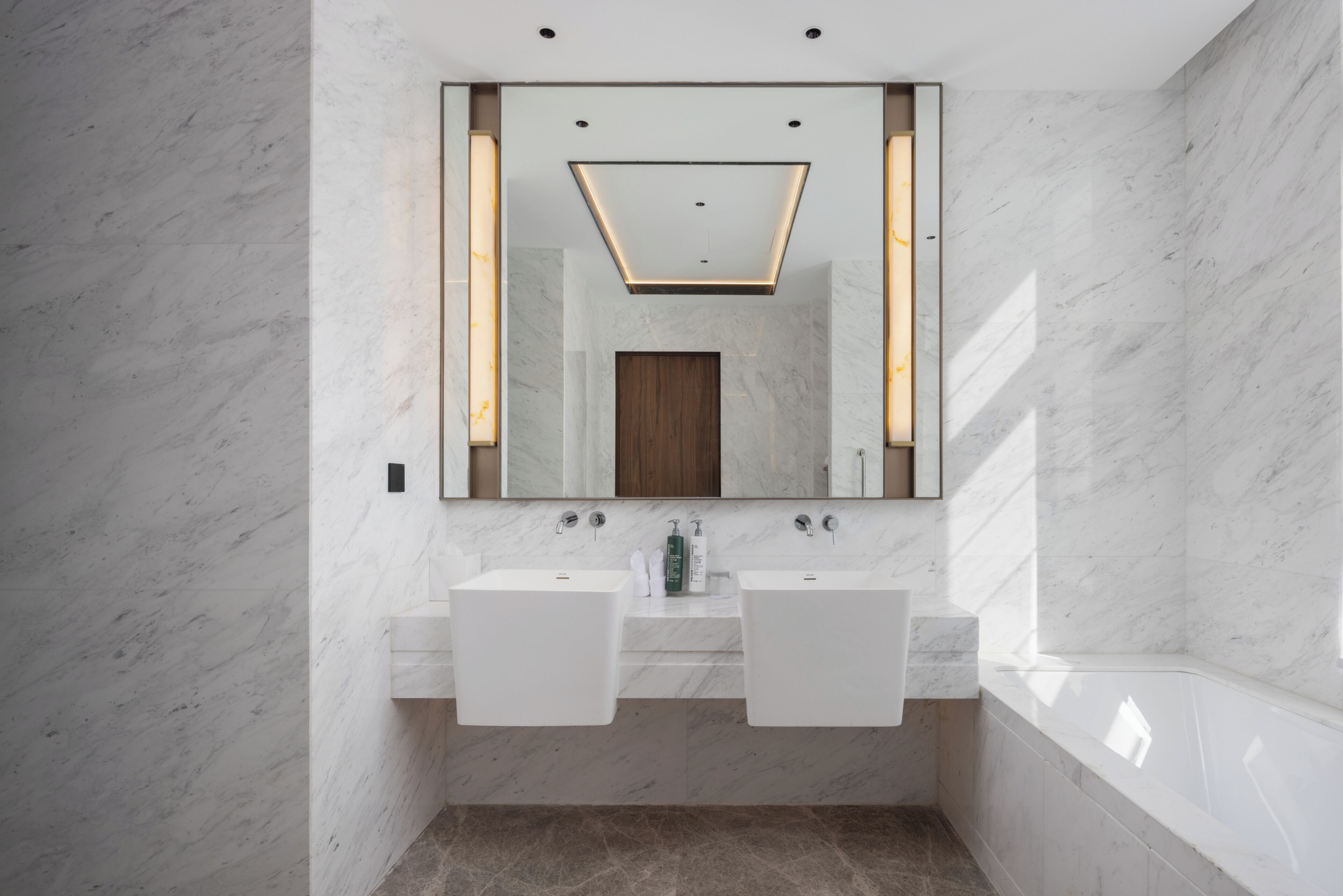 Un baño moderno con dos lavabos, un espejo grande y un mueble de madera.