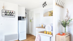 Una cocina moderna con electrodomésticos blancos, un botellero y una encimera de madera.