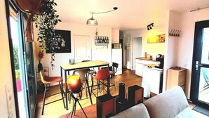 Un espacio habitable compacto con comedor, cocina y un sofá al frente.