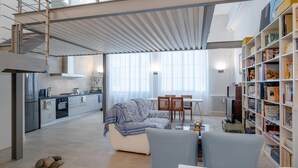 Una cocina moderna con comedor, sofá y estantería.