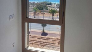 A view through a window with a clear sky and the ocean in the background. - Sea House Agadir (Agadir)