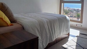 A bedroom with a bed, a window, and a view of the outside. - Sea House Agadir (Agadir)