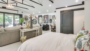 Ein modernes Schlafzimmer mit einem großen Bett, einer Couch, einem Schreibtisch und einem Kleiderschrank.