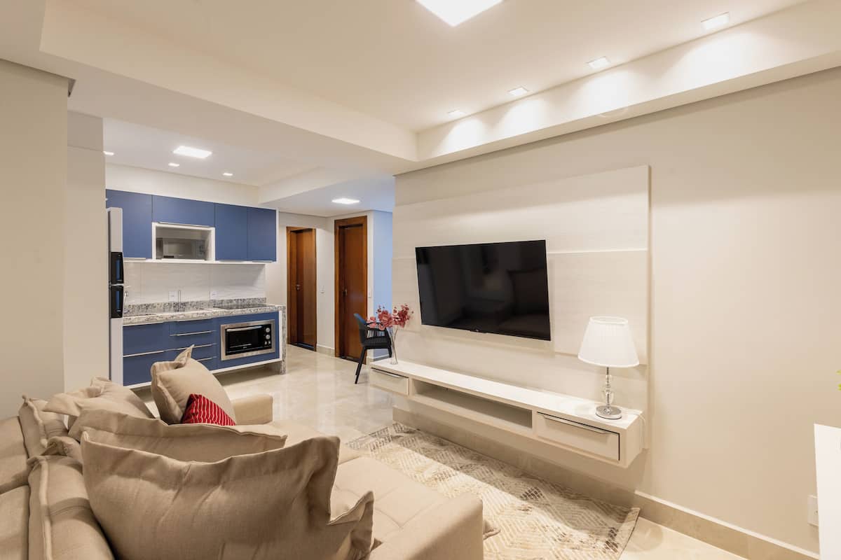 A modern living room with a flat-screen TV, a sofa, and a coffee table.