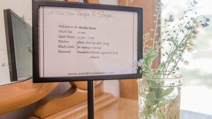 A sign with room information including check-out time, quiet hours, kitchen cleaning instructions, and a password. - Amelia Room BW Boutique Hotel (Central Lake)