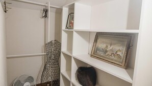 A room with a white shelving unit, a framed picture, and a fan. - Amelia Room BW Boutique Hotel (Central Lake)