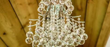 Un candelabro con múltiples elementos de cristal colgando de un techo de madera.