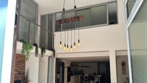 Een modern appartement met keuken, eethoek en een balkon met hangende lampjes.