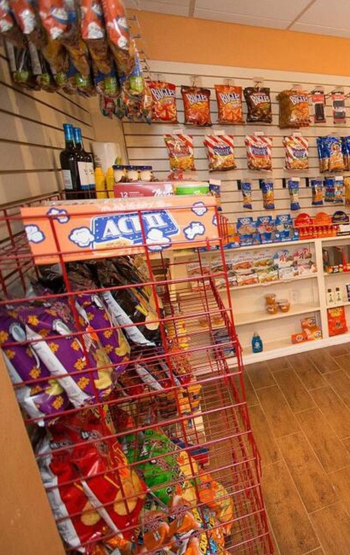 En hylla med olika sorters förpackade snacks och ett rött displayställ.