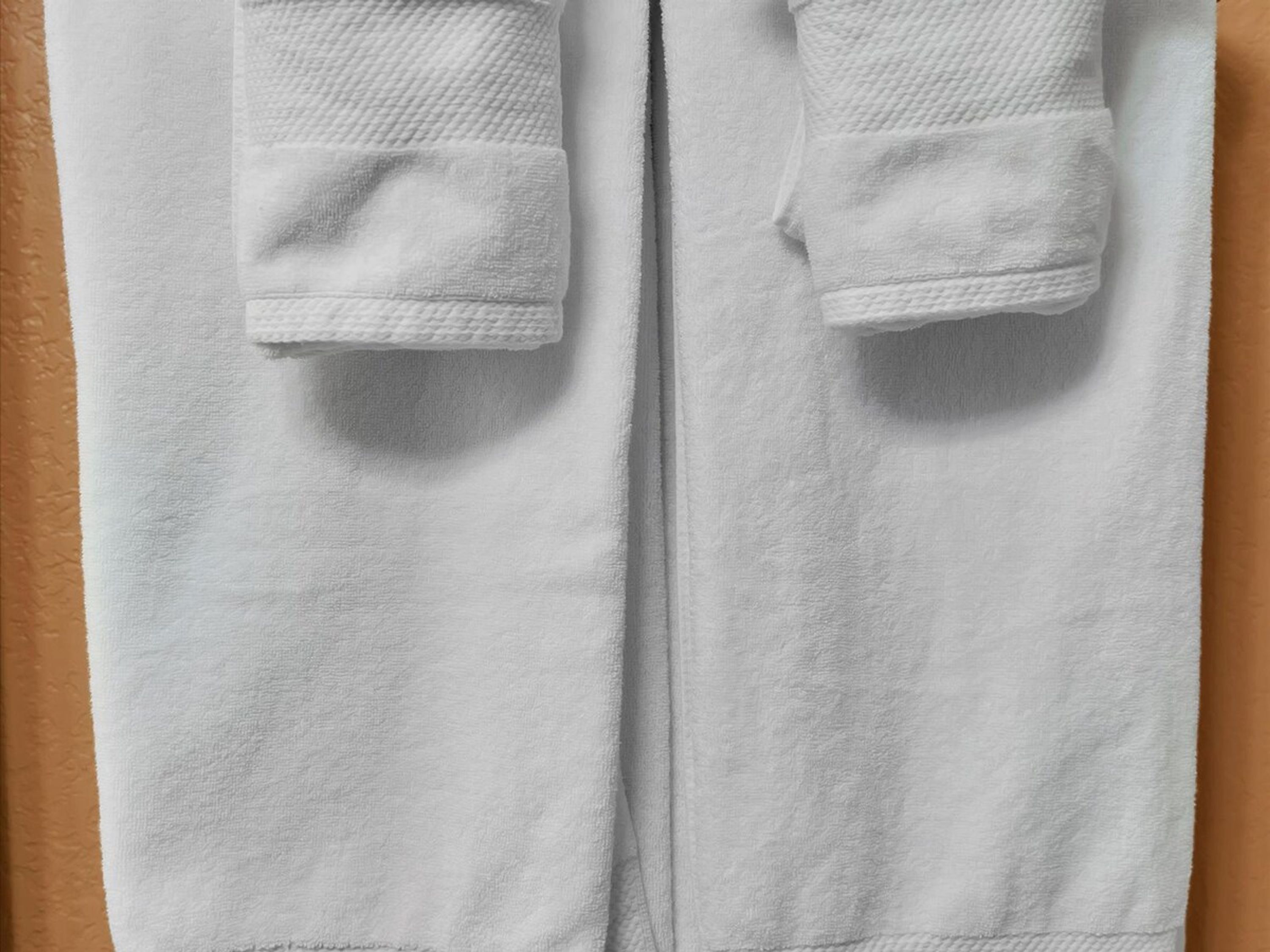 Toalla blanca de bordes doblados y superficie texturizada, probablemente para usar en un baño.