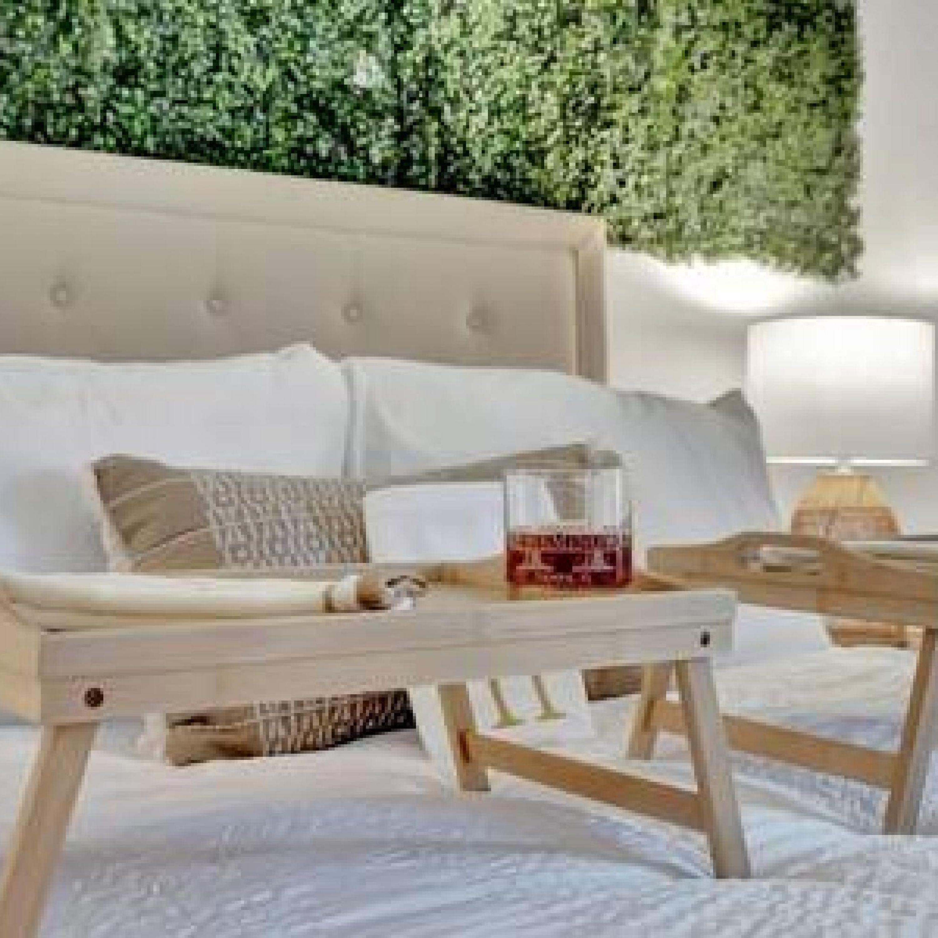 A modern bedroom with a bed, bedside table, and a wall-mounted green plant.