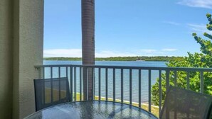 A glass-top table with chairs on a balcony overlooking a body of water. - The Bayview a Quaint 1 1 Balcony on the bay (St. Petersburg)