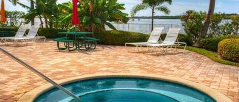 A swimming pool with lounge chairs and palm trees.