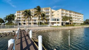 A waterfront hotel with multiple balconies, a dock, and palm trees. - The Bayview a Quaint 1 1 Balcony on the bay (St. Petersburg)