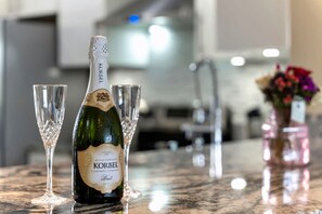 Uma garrafa de champanhe Korbel e dois copos sobre um balcão de mármore.