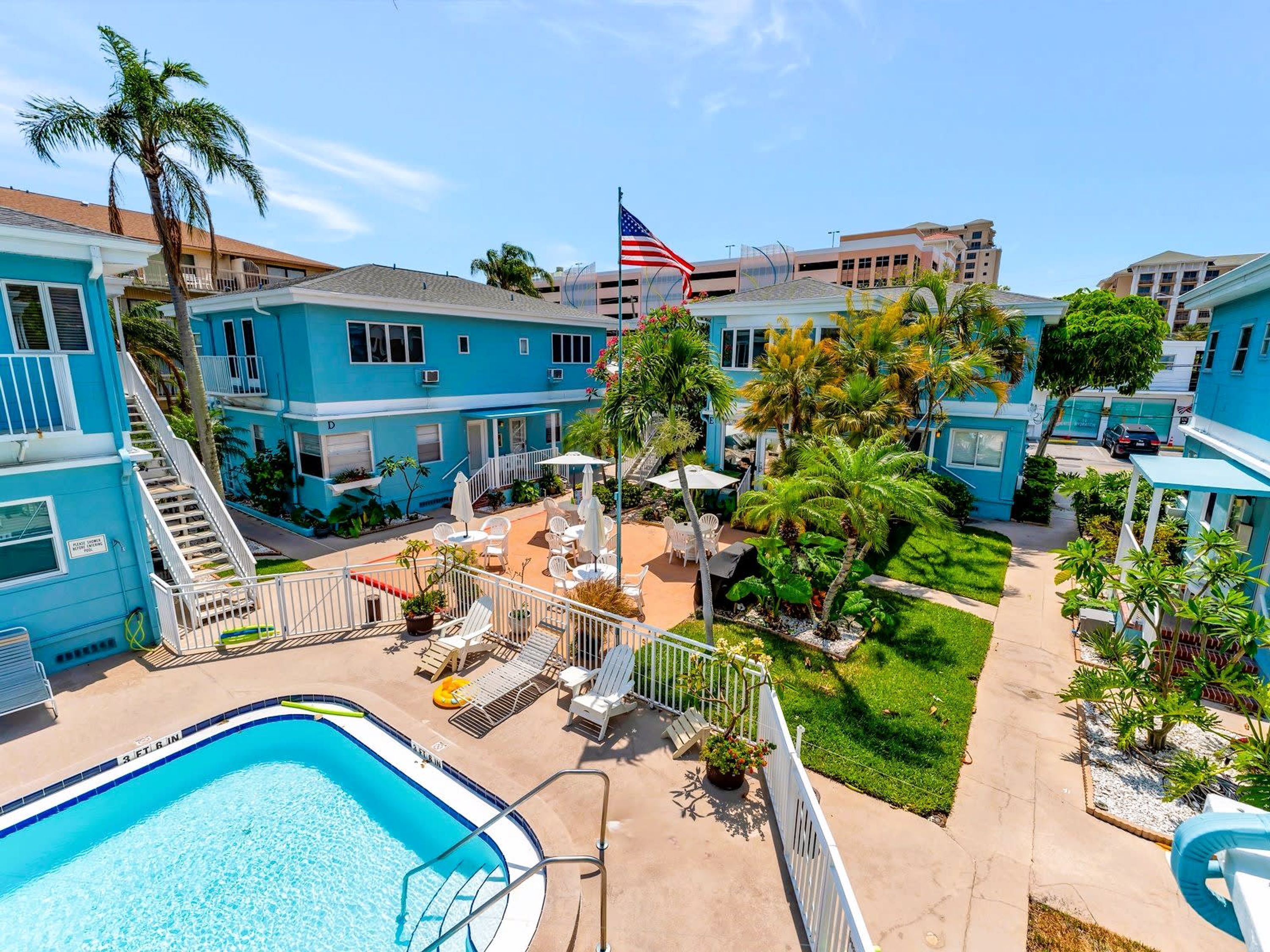 Un resort con piscina, zona de estar exterior y una bandera.