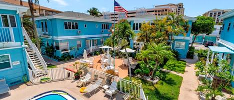 Un resort con piscina, zona de estar exterior y una bandera.