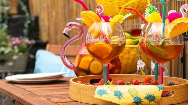 A wooden table with two glass drinks, each with a colorful straw and a fruit garnish. - Short Walk to I360 and Beach 5 Condo With Patio (Brighton)