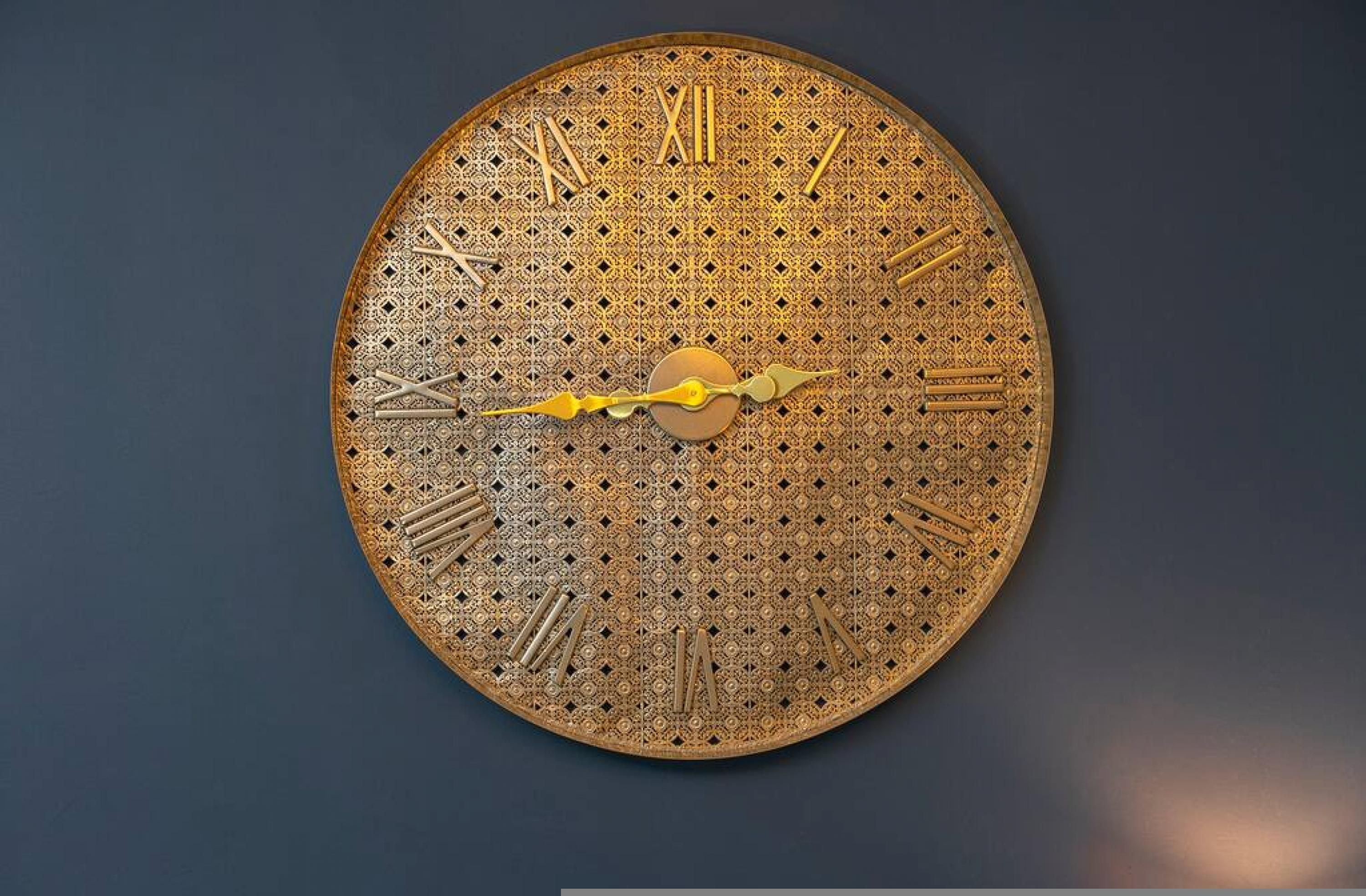 A large, ornate wall clock with intricate patterns and Roman numerals.