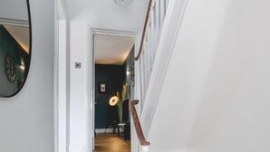 A staircase with white railings and wooden steps leading to a dark room. - Designer Retreat 5 Location Balcony Parking (Hove)